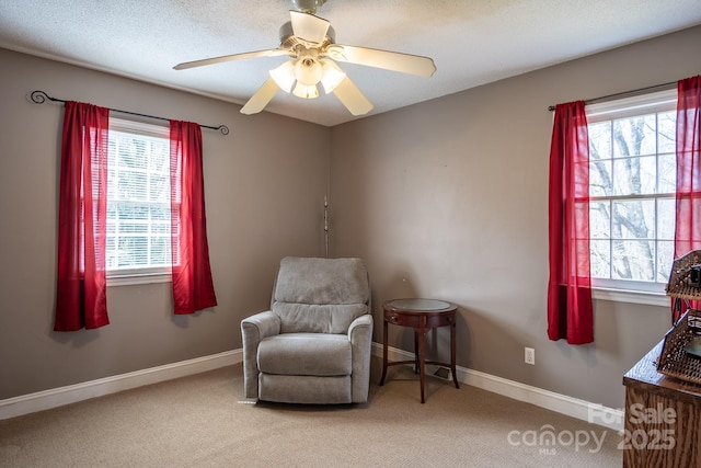 sitting room featuring baseboards, carpet, and a healthy amount of sunlight