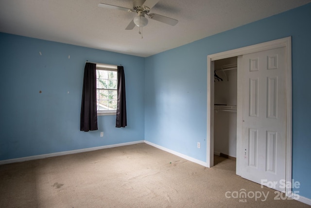 unfurnished bedroom with light carpet, baseboards, ceiling fan, a textured ceiling, and a closet