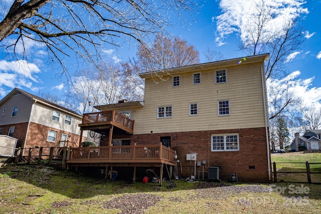 rear view of property featuring central AC unit, a balcony, fence, a wooden deck, and brick siding