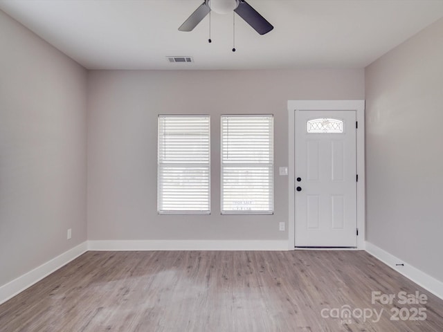 entryway featuring baseboards, visible vents, and wood finished floors