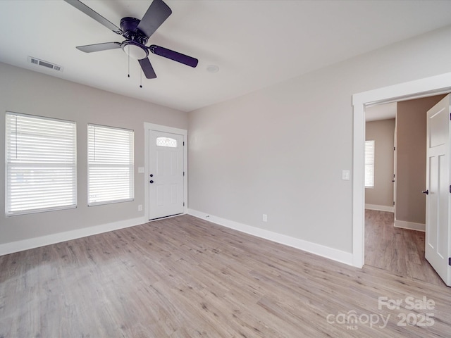 interior space featuring light wood-type flooring, baseboards, visible vents, and a ceiling fan