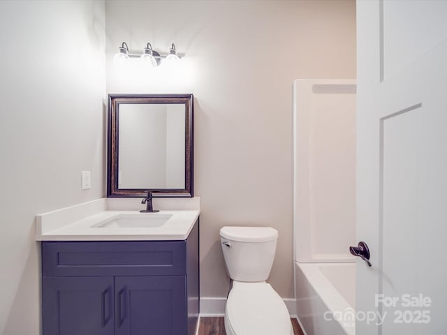 bathroom with baseboards, vanity, and toilet