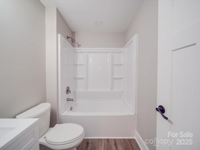 full bath with toilet, bathing tub / shower combination, wood finished floors, and vanity