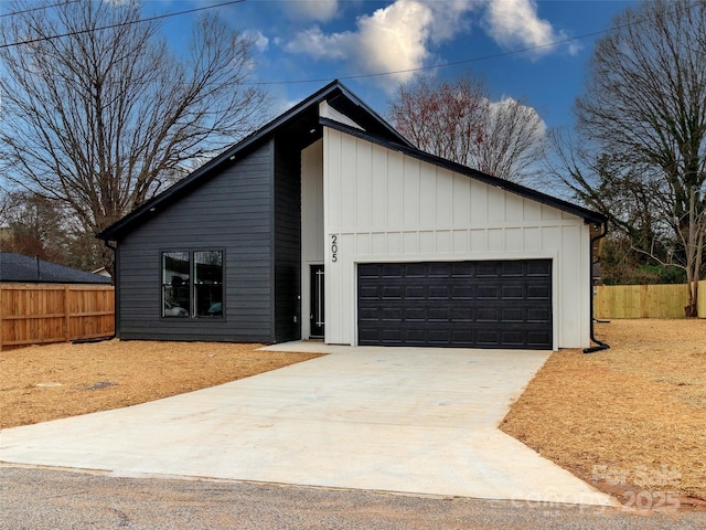 view of front of home with an attached garage, fence, and concrete driveway