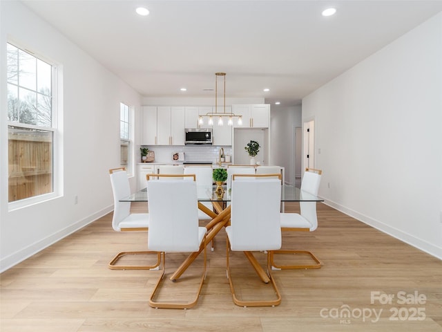 dining room with light wood-style floors, recessed lighting, and baseboards