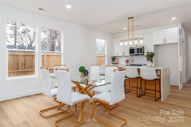 dining room with light wood-style floors, baseboards, visible vents, and recessed lighting