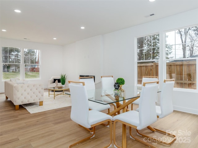 dining space with light wood-style flooring, visible vents, and recessed lighting