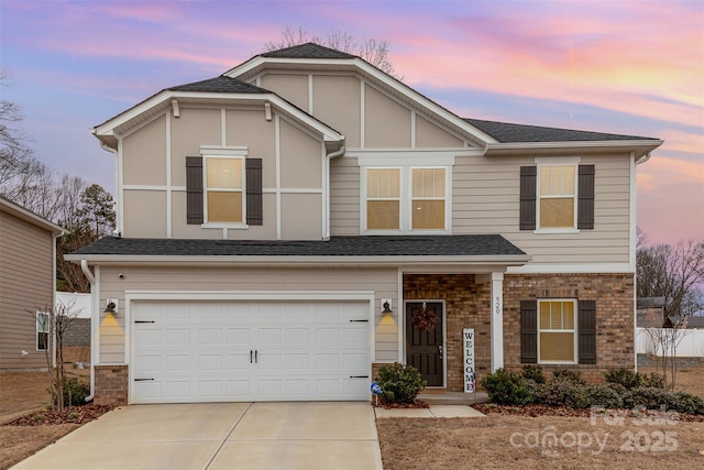 view of front of home with driveway, roof with shingles, a garage, and brick siding