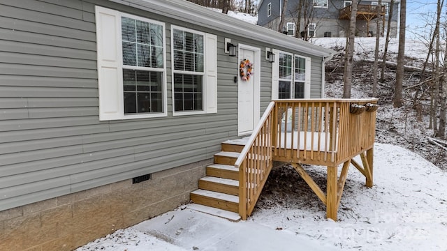 snow covered property entrance with crawl space and a wooden deck