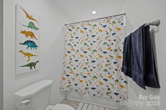 bathroom featuring ornamental molding, a shower with shower curtain, and toilet