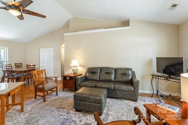 living area with vaulted ceiling, visible vents, wood finished floors, and a ceiling fan