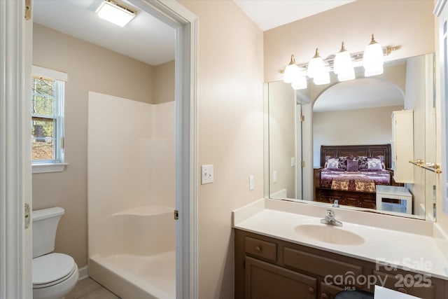 ensuite bathroom with ensuite bathroom, tile patterned flooring, toilet, vanity, and a shower stall