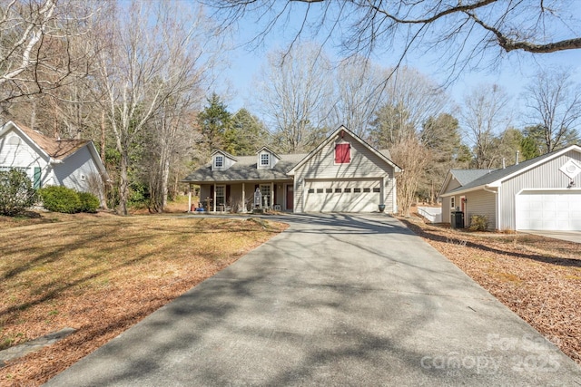 view of front of home with driveway, a garage, a porch, and a front yard