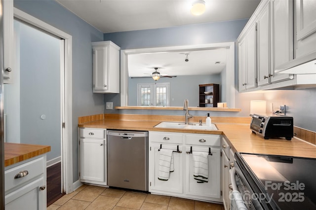 kitchen with light tile patterned floors, white cabinets, a ceiling fan, appliances with stainless steel finishes, and a sink