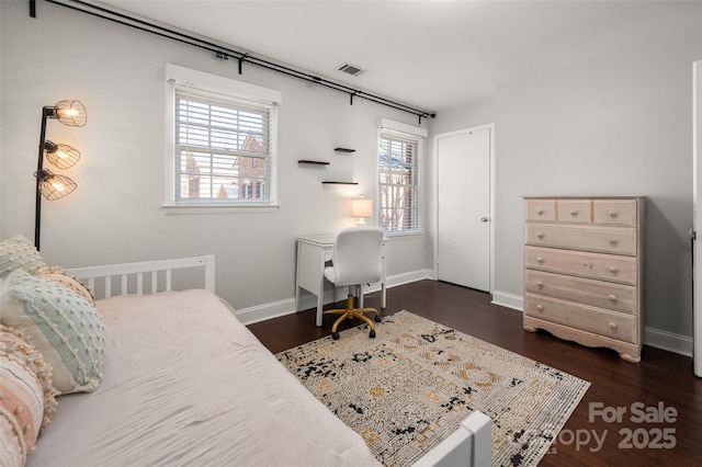 bedroom with visible vents, dark wood finished floors, and baseboards