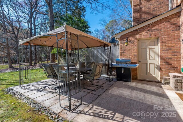 view of patio / terrace with a gazebo, outdoor dining area, grilling area, and fence