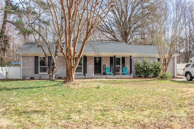 single story home featuring brick siding, crawl space, fence, a porch, and a front yard