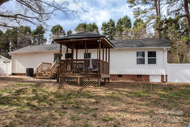 rear view of property featuring crawl space, fence, central AC, and a wooden deck