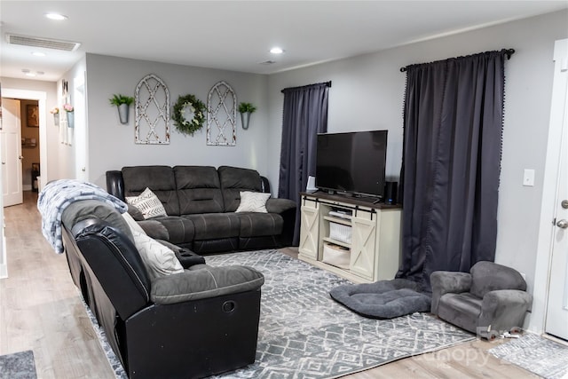 living area with wood finished floors, visible vents, and recessed lighting