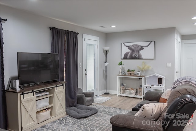 living area with recessed lighting, baseboards, and wood finished floors