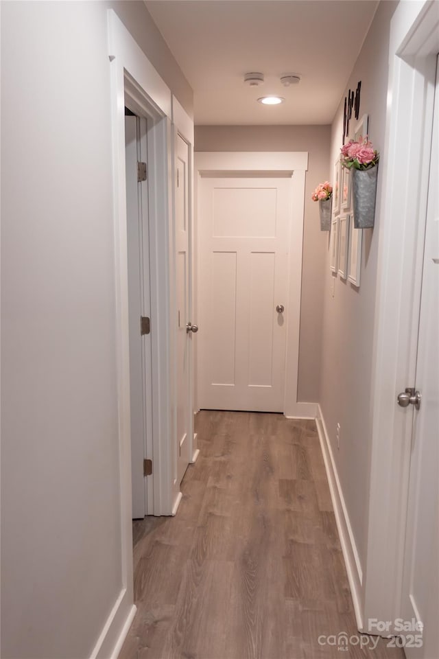 hallway with baseboards and wood finished floors