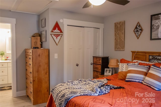 bedroom featuring ensuite bathroom, a closet, light wood-type flooring, and a ceiling fan