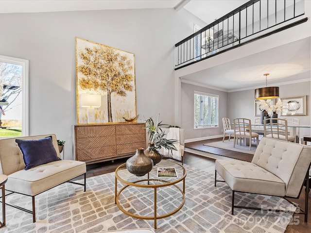 living room featuring high vaulted ceiling, ornamental molding, wood finished floors, and baseboards