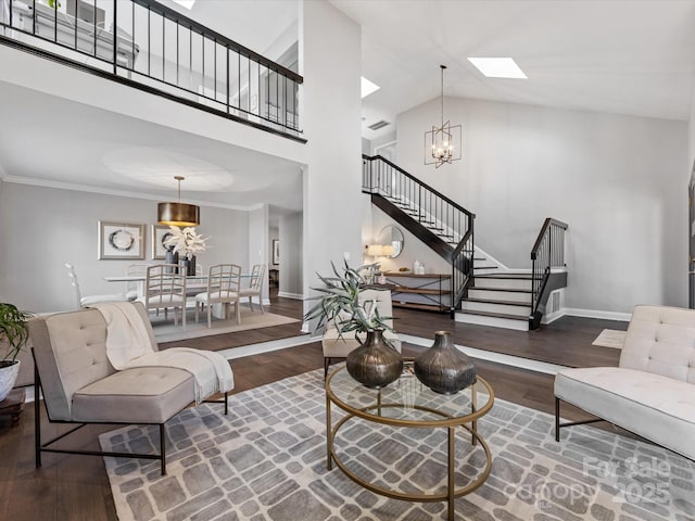 living room with dark wood-style flooring, stairway, a skylight, and a notable chandelier