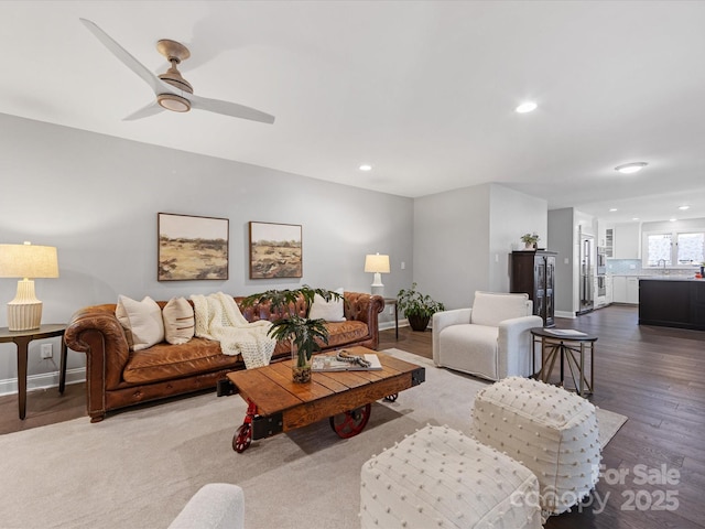 living area with baseboards, wood finished floors, a ceiling fan, and recessed lighting