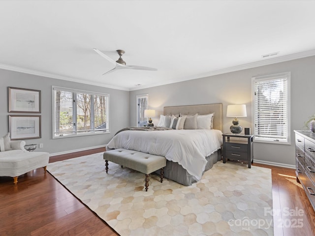 bedroom featuring visible vents, crown molding, light wood-style flooring, and baseboards