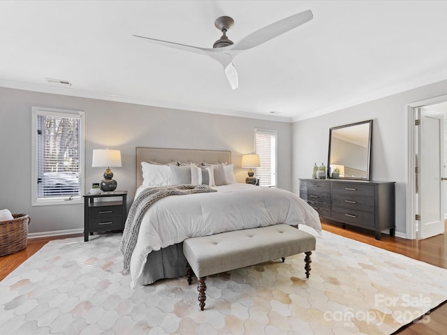 bedroom with visible vents, baseboards, ceiling fan, wood finished floors, and crown molding