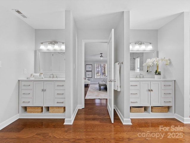 full bath with a sink, visible vents, connected bathroom, and wood finished floors