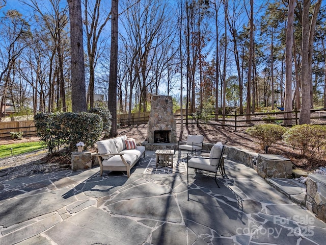 view of patio with fence and an outdoor living space with a fireplace