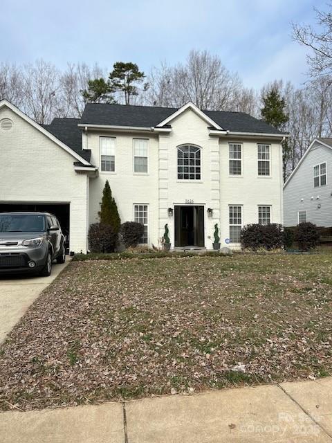 colonial-style house with a garage and driveway