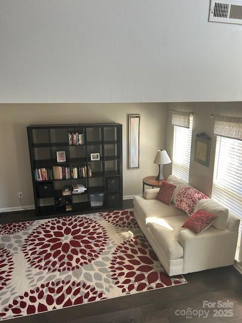 living area with baseboards and visible vents