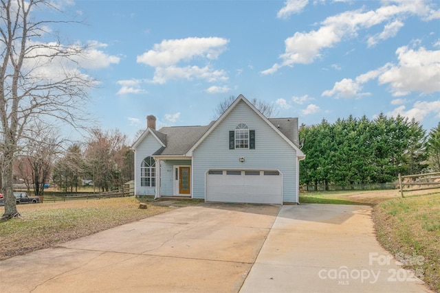 traditional home featuring an attached garage, fence, driveway, a front lawn, and a chimney