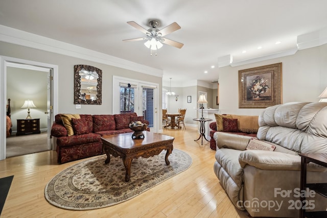 living room featuring baseboards, a ceiling fan, crown molding, light wood-type flooring, and recessed lighting