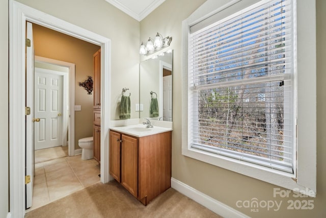 bathroom featuring crown molding, toilet, vanity, baseboards, and tile patterned floors