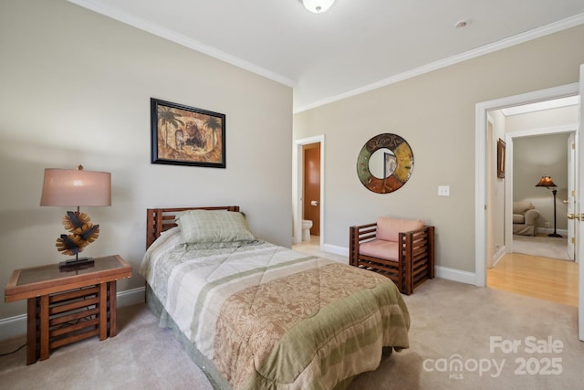 bedroom with ornamental molding, light carpet, connected bathroom, and baseboards