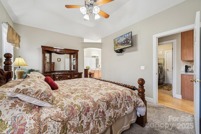 bedroom featuring baseboards, arched walkways, ceiling fan, a tray ceiling, and carpet flooring
