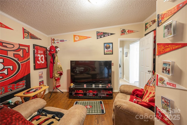 living area with crown molding, a textured ceiling, baseboards, and wood finished floors