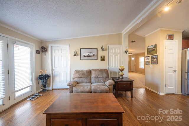 living room featuring crown molding, a textured ceiling, and wood finished floors