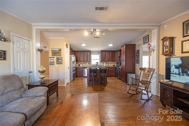 living room featuring visible vents, crown molding, a textured ceiling, and wood finished floors