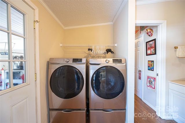 washroom featuring crown molding, washing machine and clothes dryer, a textured ceiling, wood finished floors, and laundry area