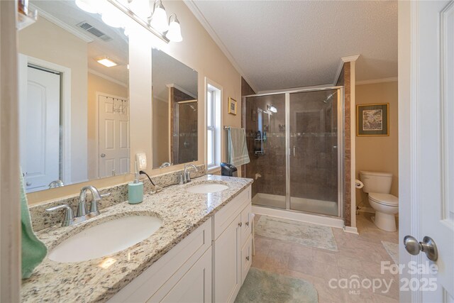 full bath featuring toilet, a stall shower, crown molding, and a sink