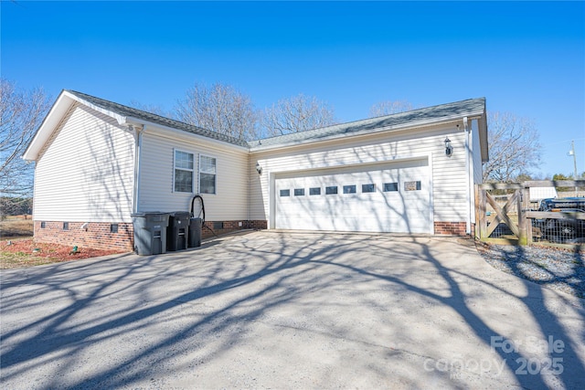 view of home's exterior with crawl space, driveway, a garage, and a gate