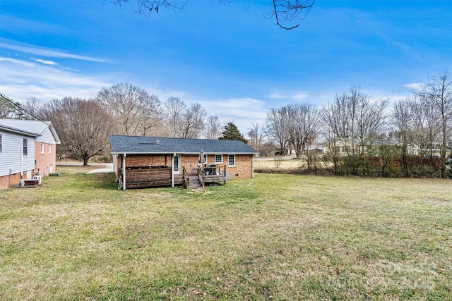 rear view of house with crawl space, brick siding, and a yard