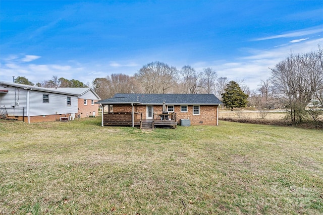 back of property with crawl space, brick siding, a lawn, and central air condition unit