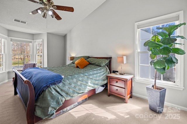 bedroom with lofted ceiling, baseboards, visible vents, and light colored carpet