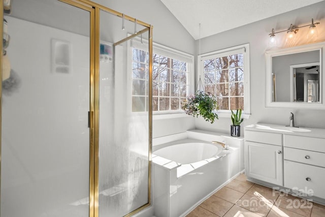 bathroom with lofted ceiling, vanity, a shower stall, a bath, and tile patterned floors